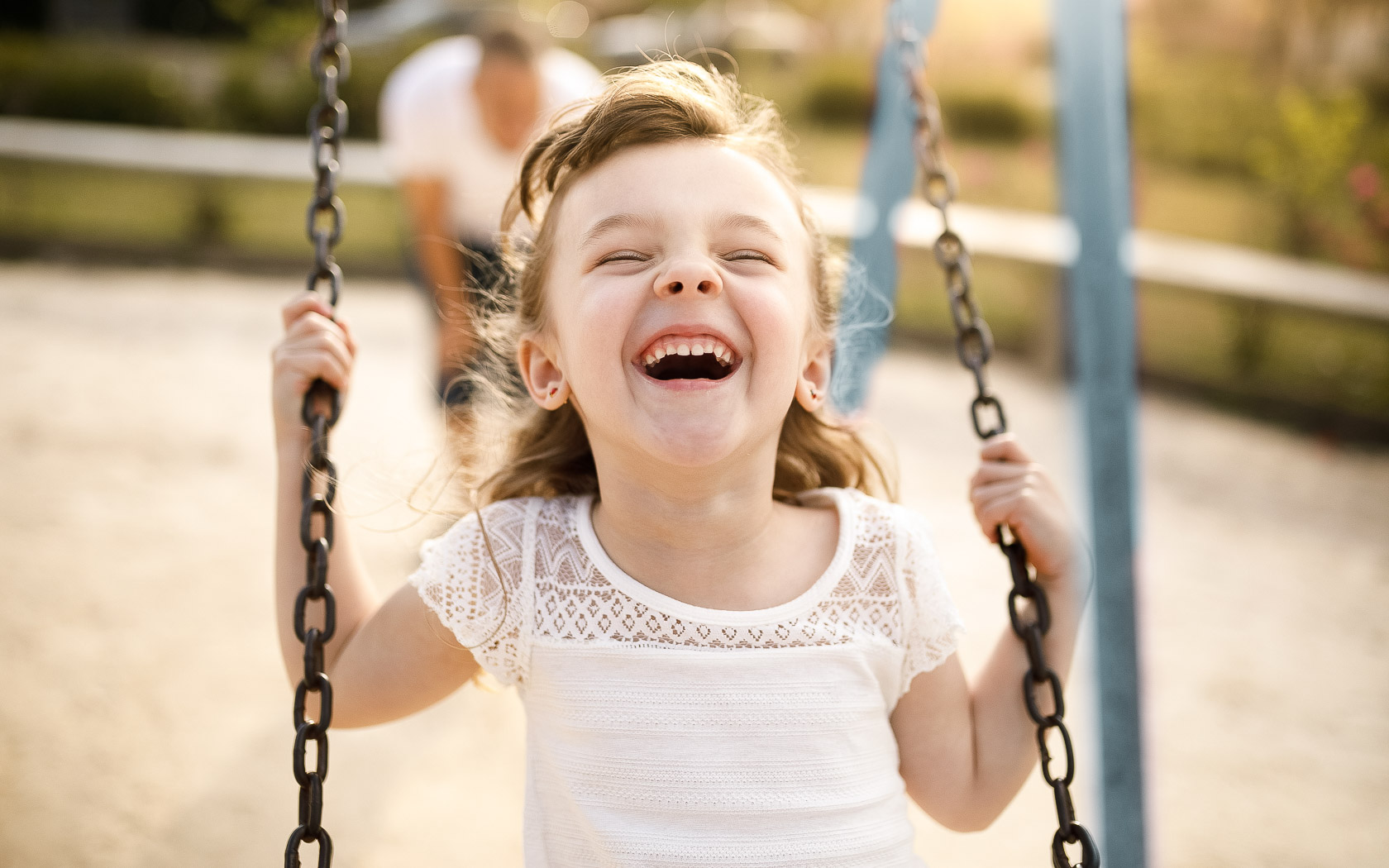 Smiling girl playing on the swing